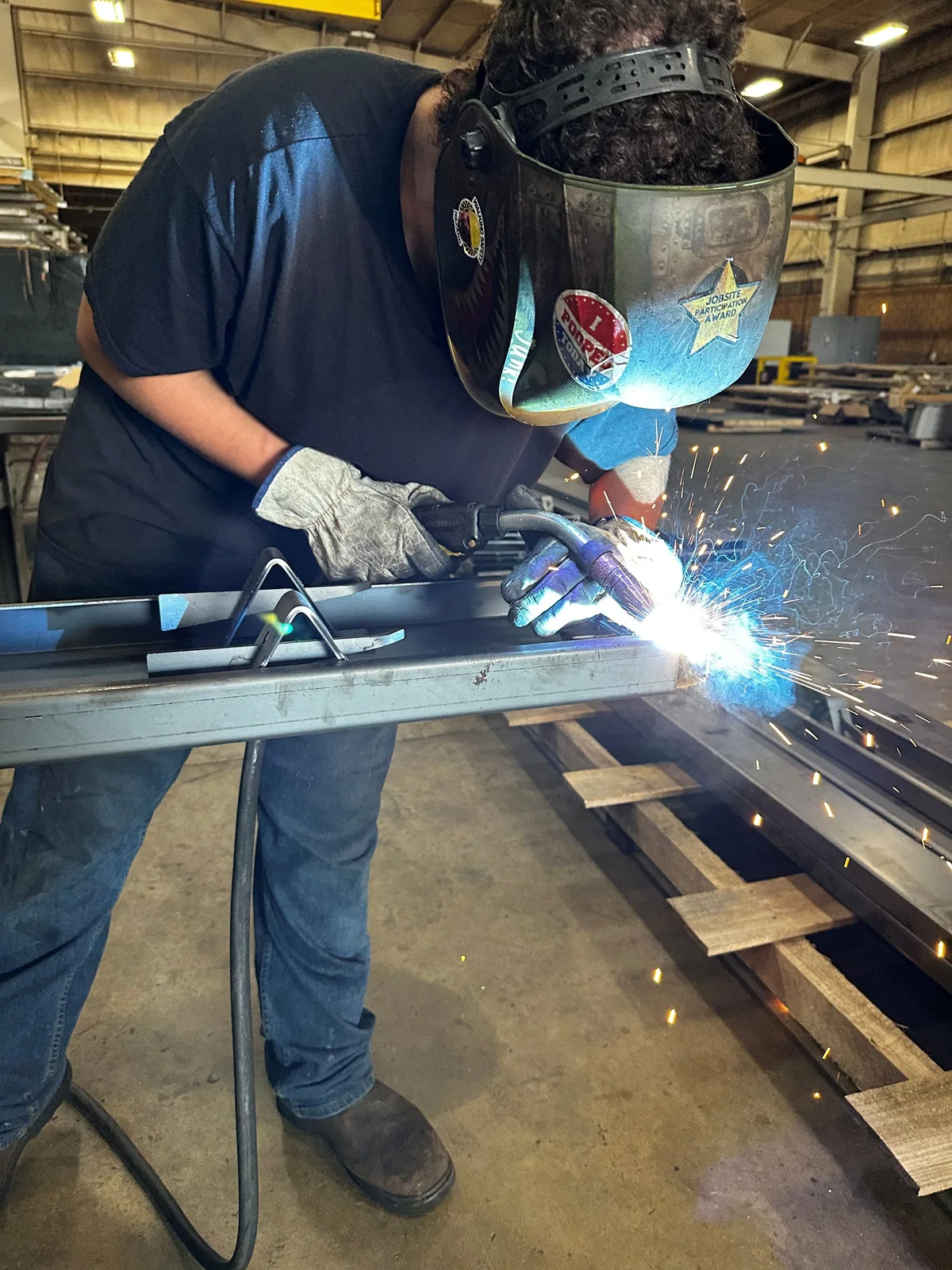 Worker welding a straight concrete form